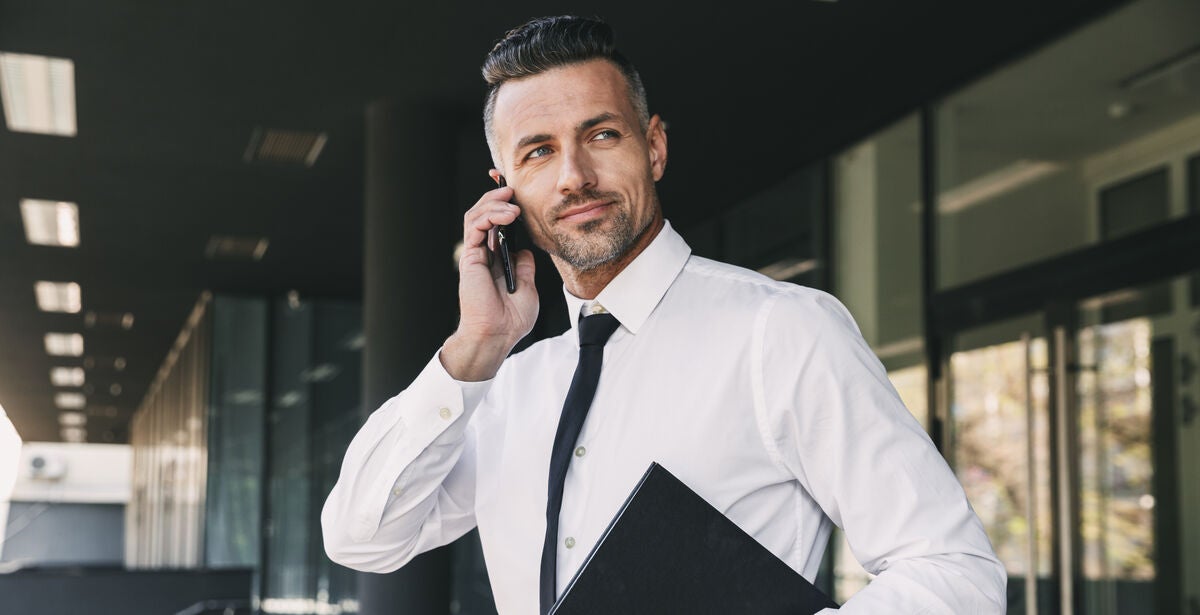 A-man-in-work-attire-holding-up-his-phone-asking-someone-whether-a-masters-degree-is-good.