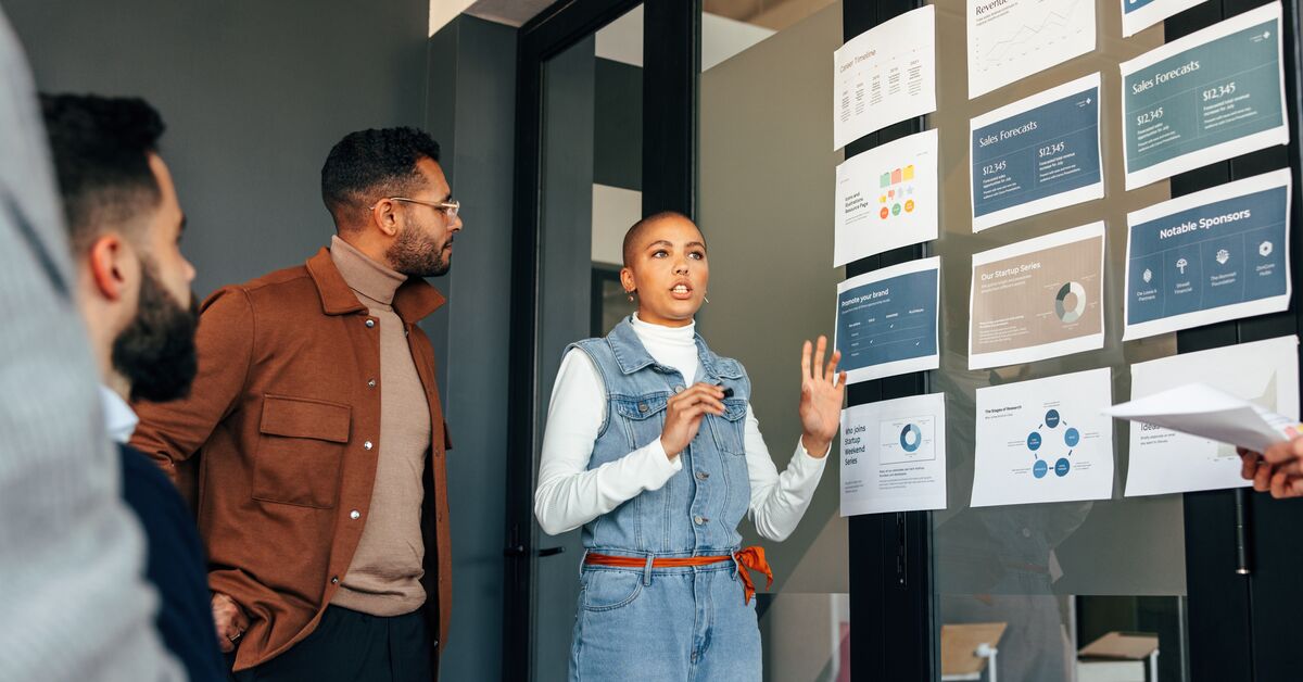 A woman presenting in front of her colleagues are online masters degree respected