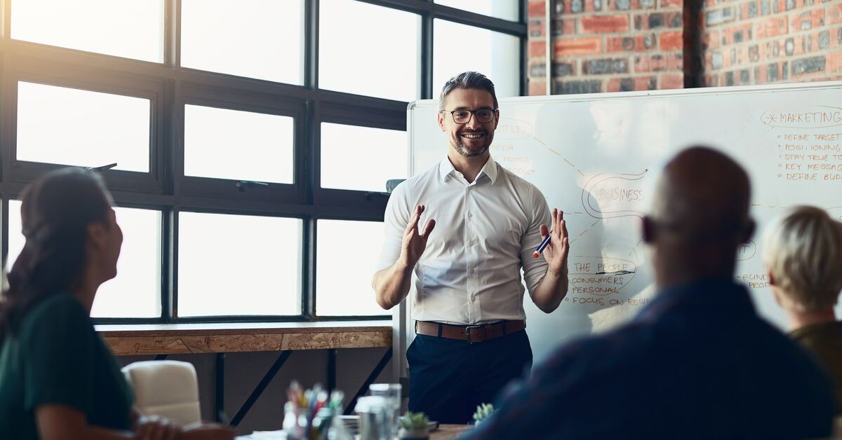 A man teaching a group of three about master online marketing digital