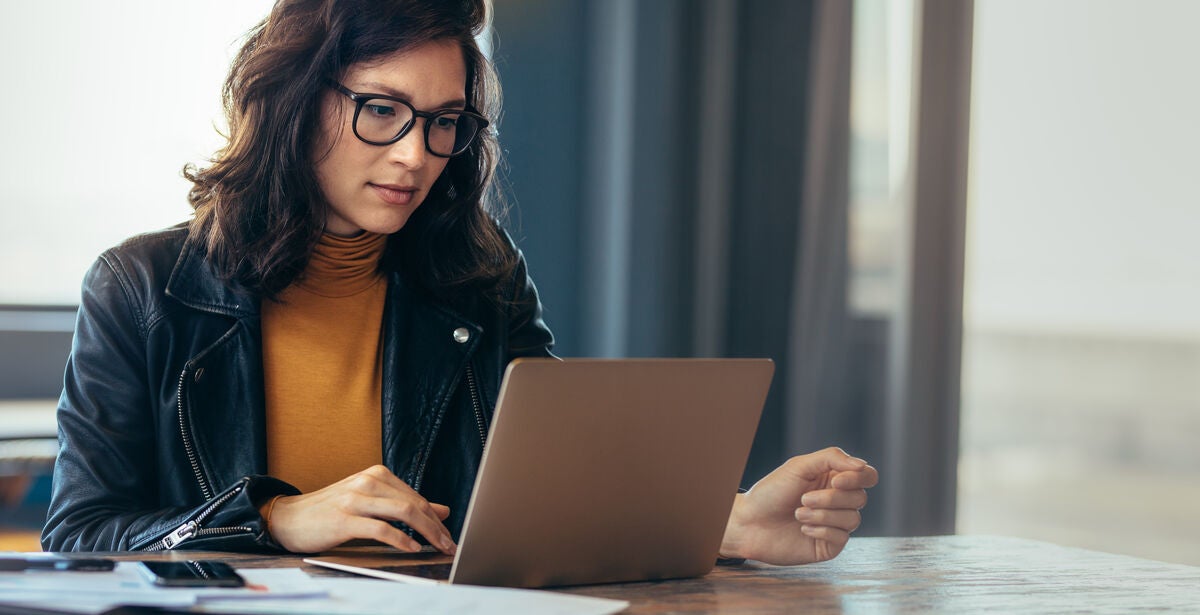 A young woman sits at a desk watching a video on what do you do with an MBA.