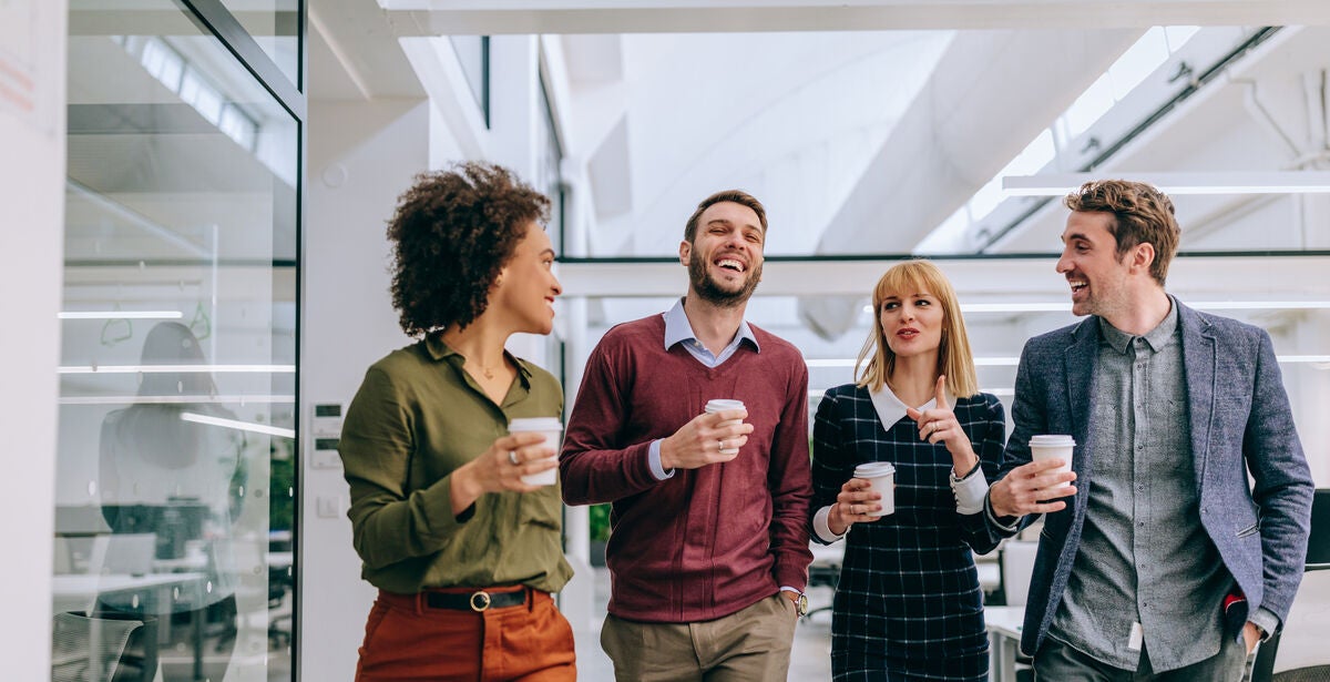 A group of professionals are huddled together, discussing what an MBA can teach them.